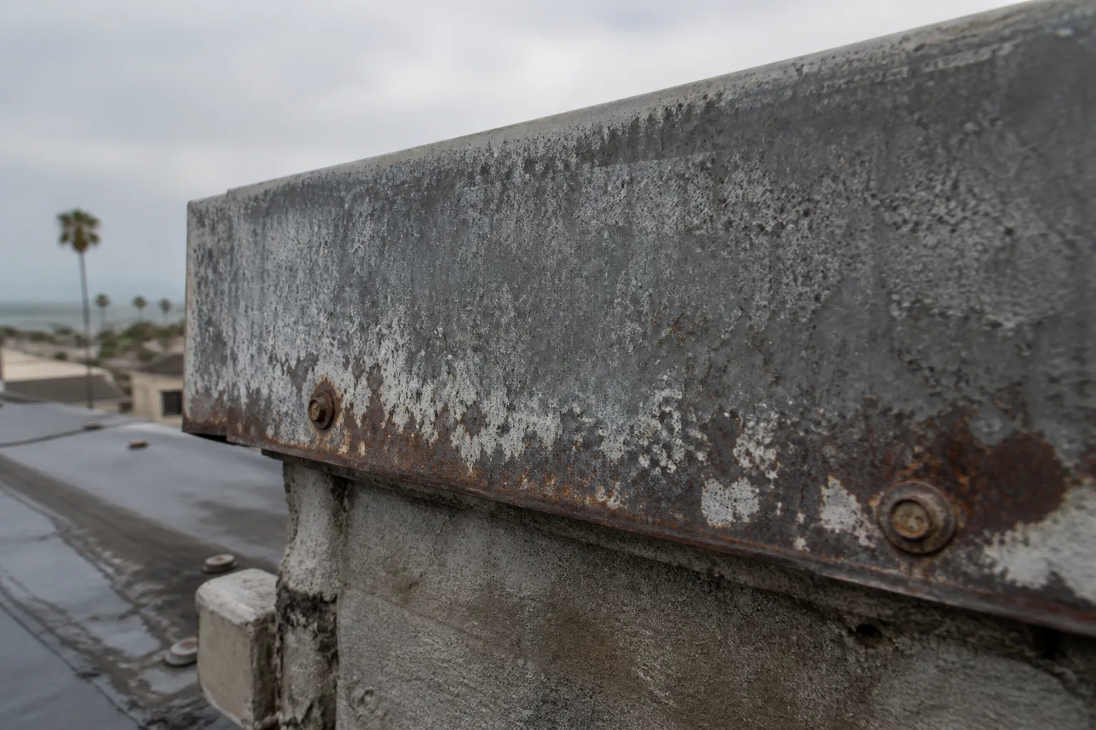 Weathered metal roof flashing with corrosion and oxidation.